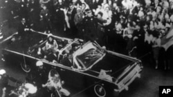 Imagen proporcionada por la Comisión Warren de una vista aérea del automóvil del presidente John F. Kennedy en la caravana de Dallas el 22 de noviembre de 1963. Se muestra al agente especial Clinton J. Hill viajando en la parte trasera de la limusina.