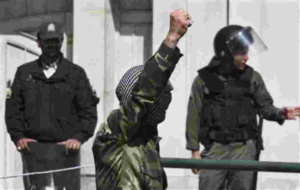 A demonstrator chants slogans in front of the Bahraini Embassy in Tehran, Iran as he covers his face in the style of Palestinian militants, in a protest against Saudi and Bahraini leaders to condemn the crackdown on the Bahraini opposition, April 15, 2011