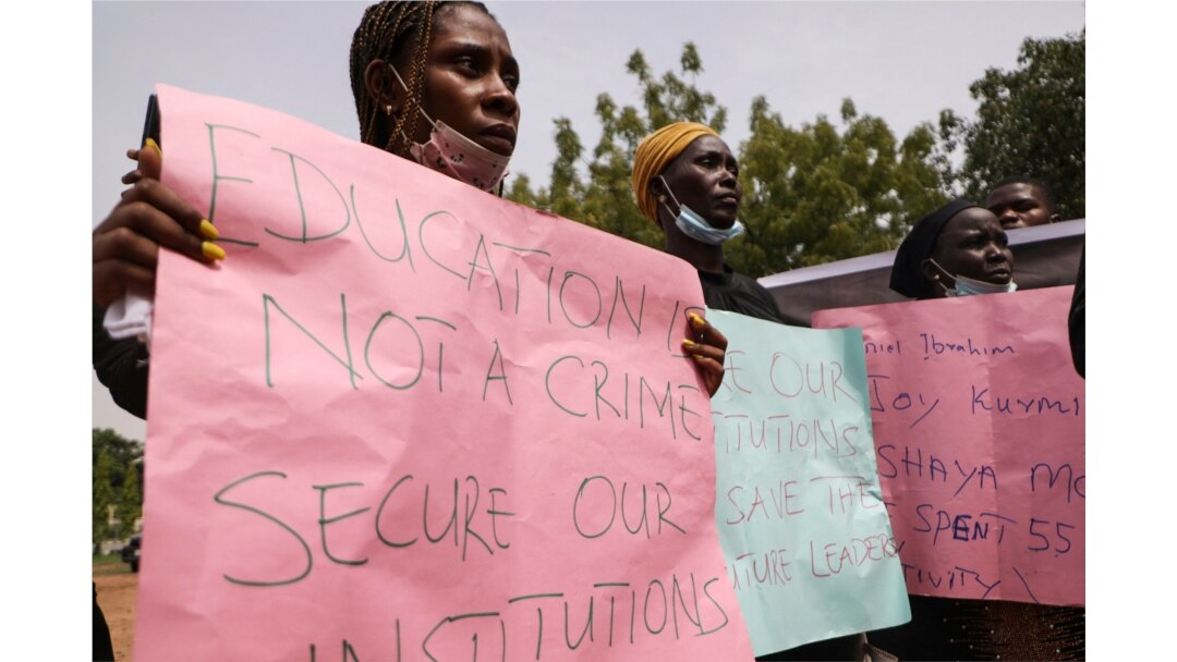 Parents and relatives of students from the Federal College of Forestry Mechanization in Kaduna who have been abducted, hold placards during a demonstration in Abuja on May 4, 2021.