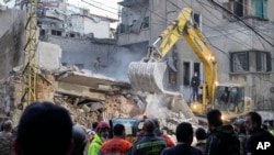 Rescuers use an excavator as they search for victims at the site of an Israeli airstrike that hit a building in Beirut on Nov. 26, 2024.