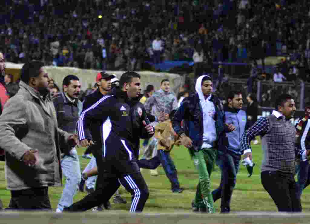 Pendukung sepakbola meninggalkan stadiun saat bentrokan dimulai di Stadion Kairo, Port Said, Mesir (1/2) (REUTERS).