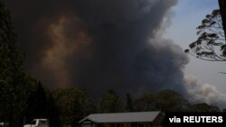 A home is seen as smoke from the Grose Valley Fire rises in the distance, at Bilpin, New South Wales, Australia, Dec. 21, 2019.