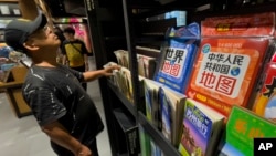 资料照：一名男子在北京一家书店的新版地图展架前。（2023年9月1日）