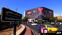 Commuters drive past a large anti-Israeli billboard displayed in Enghelab Square in Tehran on October 26, 2026.