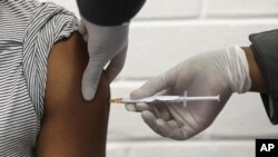FILE - In this Wednesday, June 24, 2020 file photo, a volunteer receives an injection at the Chris Hani Baragwanath hospital in Soweto, Johannesburg, as part of Africa's first participation in a COVID-19 vaccine trial developed at the University of…