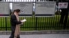 A woman reads a notification about canceling her visa appointment due to Colombian President Gustavo Petro's refusal to accept repatriation flights for Colombian citizens from the United States, outside the U.S. Embassy in Bogota, Colombia, Jan. 27, 2025.