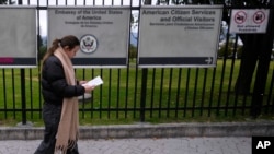 A woman reads a notification about canceling her visa appointment due to Colombian President Gustavo Petro's refusal to accept repatriation flights for Colombian citizens from the United States, outside the U.S. Embassy in Bogota, Colombia, Jan. 27, 2025.