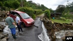 Deux hommes se tiennent debout dans les débris après les inondations qui ont causé d'importants dégâts à Hagen, dans l'ouest de l'Allemagne, le 15 juillet 2021.