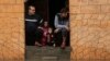 Palestinian residents, stranded in an inundated house, stare out of the entrance of their home, following torrential rains that hit the Jabalia refugee camp in the northern Gaza strip, Jan. 16, 2022.