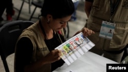 A woman takes part in a hand count of some of the votes cast in Honduras' recent presidential election in Tegucigalpa, Dec. 7, 2017.