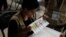 A woman takes part in a hand count of some of the votes cast in Honduras' recent presidential election in Tegucigalpa, Dec. 7, 2017.