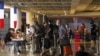 Visitors queue to register their documents with a French Embassy officer before their chartered flight back to their country, amid the spread of COVID-19, at Ngurah Rai International Airport in Bali, Indonesia, March 28, 2020.