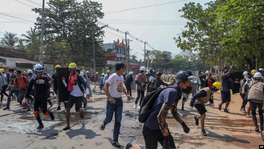 Para pengunjuk rasa antikudeta lari menyelamatkan diri setelah polisi menembakkan granat dan peluru karet di Yangon, Myanmar, Kamis, 11 Maret 2021.