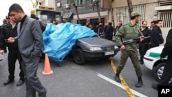 Photo provided by the International Iran Photo Agency shows Iranian security forces standing guard around the site of an explosion near a university in Tehran, January 11, 2012.