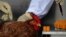 Officials from the Center for Food Safety get a blood sample from a chicken imported from mainland China at a border checkpoint in Hong Kong, April 11, 2013. 