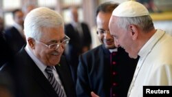 Pope Francis talks to Palestinian President Mahmoud Abbas (L) during a private audience in the pontiff library at the Vatican, Oct. 17, 2013. 