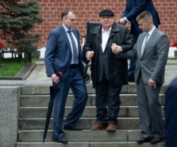 FILE - Former Soviet leader Mikhail Gorbachev, center, is helped by his assistants as he arrives to attend the Victory Day military parade to celebrate 74 years since the victory in WWII in Red Square in Moscow, May 9, 2019.