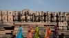 Devotees walk past the pillars that Hindu nationalist group Vishva Hindu Parishad (VHP) say will be used to build a Ram temple at the disputed religious site in Ayodhya, India, Oct. 22, 2019.