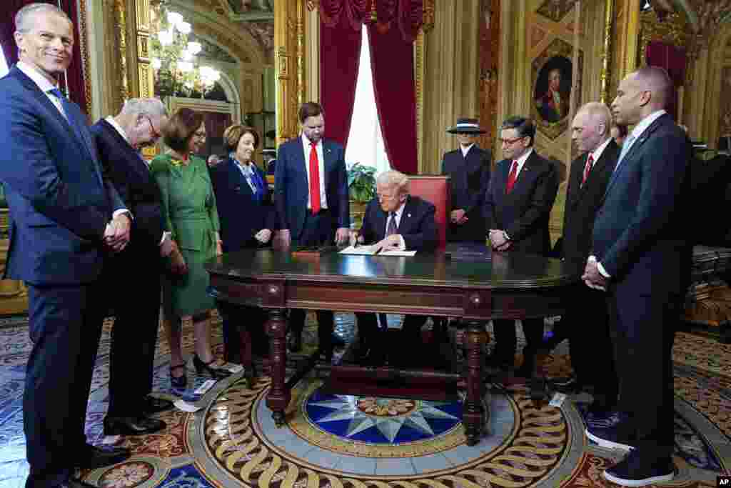 President Donald Trump, center, takes part in a signing ceremony in the President&#39;s Room, Jan. 20, 2025, at the U.S. Capitol in Washington.