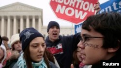 FILE - A pro-choice supporter is confronted by pro-life supporters at a rally in front of the U.S. Supreme Court in Washington, Jan. 22, 2007.