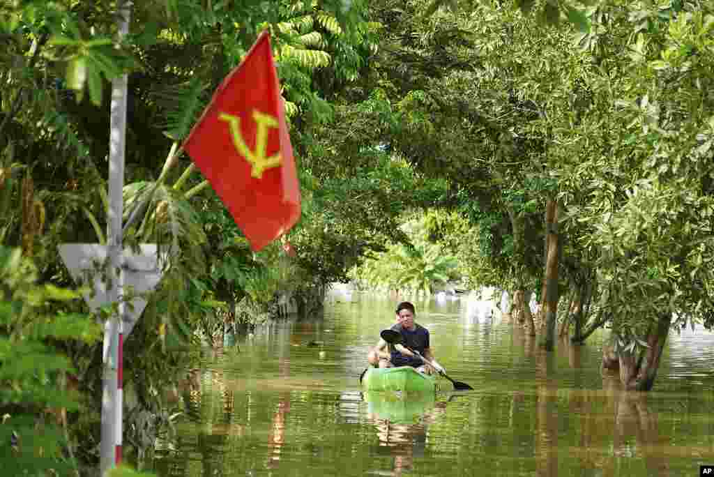 Seorang pria mendayung perahu di tengah banjir akibat Topan Yagi di desa An Lac, Hanoi, Vietnam. (AP)&nbsp;