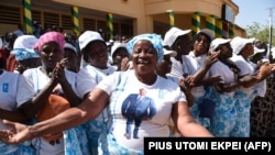 Des femmes chantent des slogans soutenant le président togolais Faure Gnassingbe durant un meeting de campagne à Dapaong, dans le nord du Togo, le 16 février 2020. (Photo by PIUS UTOMI EKPEI / AFP)