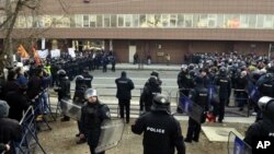 Полицијата меѓу поддржувачите на владата (лево) и на опозицијата (десно) за време на собраниските настани во Македонија на 24-ти декември 2012-та