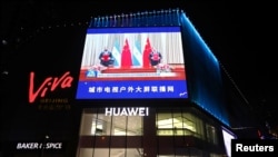 FILE - A screen shows news footage of Chinese and Nicaraguan officials at the signing in Tianjin of a communique on resumption of diplomatic relations between the two nations, in Beijing, Dec. 10, 2021.