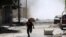 A man runs for cover during clashes between Free Syrian Army fighters and Syrian Army soldiers in the Salah al-Din neighborhood of central Aleppo August 4, 2012.