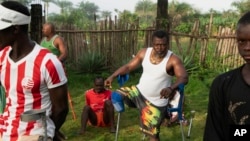 FILE - Farming trainees who lost limbs during Sierra Leone's 1991-2002 civil war do warmup exercises before starting their day at the Farming on Crutches initiative in Freetown, Sierra Leone, Sept. 25, 2024. 