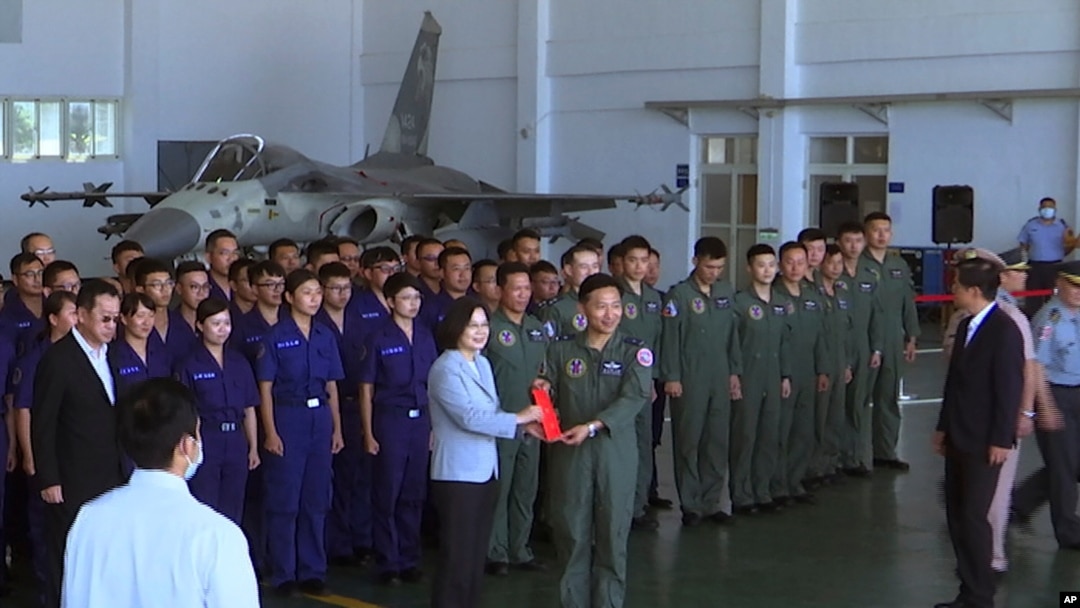Presiden Taiwan Tsai Ing-wen, kiri tengah, berfoto dengan para penerbang di dekat jet Tempur Pertahanan Pribumi Taiwan yang dipamerkan selama kunjungan ke pangkalan udara militer Penghu Magong di pulau terpencil Penghu, Taiwan, 22 September 2020. (Foto: AP )