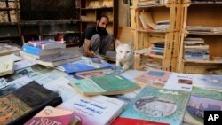 Hamzeh AlMaaytah sorts books at his Mahall al-Maa bookstore, in Jordan's capital, Amman, June 15, 2017.