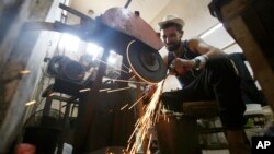 A Palestinian man sharpens a knife that will be used to slaughter cattle or cut meat during the Muslim festival of sacrifice Eid al-Adha, in a workshop in Gaza City.