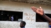 Un garçon passe devant un graffiti sur lequel il est écrit "Macky dégage" faisant référence au président sénégalais Macky Sall à Dakar, le 5 mars 2021.