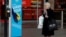 A woman smokes a cigarette as she stands by a sign encouraging people to wash their hands amid the outbreak of the coronavirus disease (COVID-19) in Belfast, Northern Ireland Jan. 2, 2021.