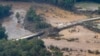 Foto yang diambil dari udara yang menunjukkan jembatan yang rusak akibat banjir yang timbul akibat terjangan badai Helene di Greene County, Tennessee, pada 28 September 2024. (Foto: AP/George Walker IV)