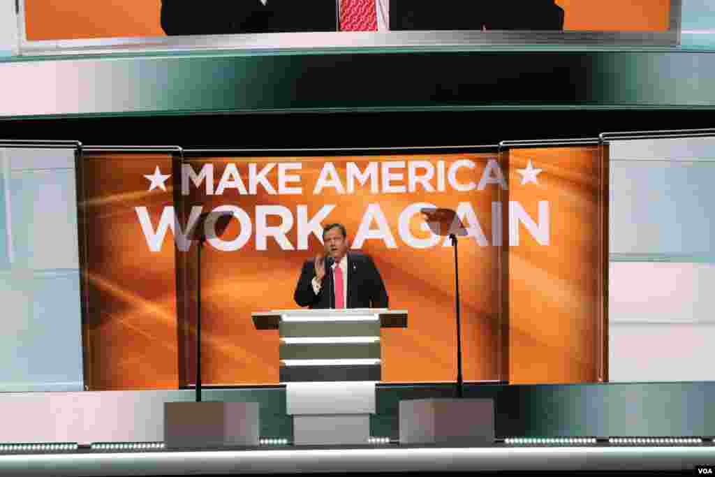 Chris Christie speaks as the theme of the second night at the Republican National Convention in Cleveland, Make America Work Again, is displayed in the background, July 19, 2016. (A. Shaker/VOA)