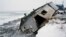 FILE - In this Dec. 8, 2006, file photo, Nathan Weyiouanna's abandoned house at the west end of Shishmaref, Alaska, sits on the beach after sliding off during a fall storm in 2005. 