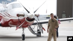 FILE - A pilot walks by a Pilatus PC-12 at Centennial Airport in the south Denver area, May 15, 2015. A Pilatus PC-12 crashed in South Dakota Saturday, killing nine of the 12 people on board. The NTSB is investigating.