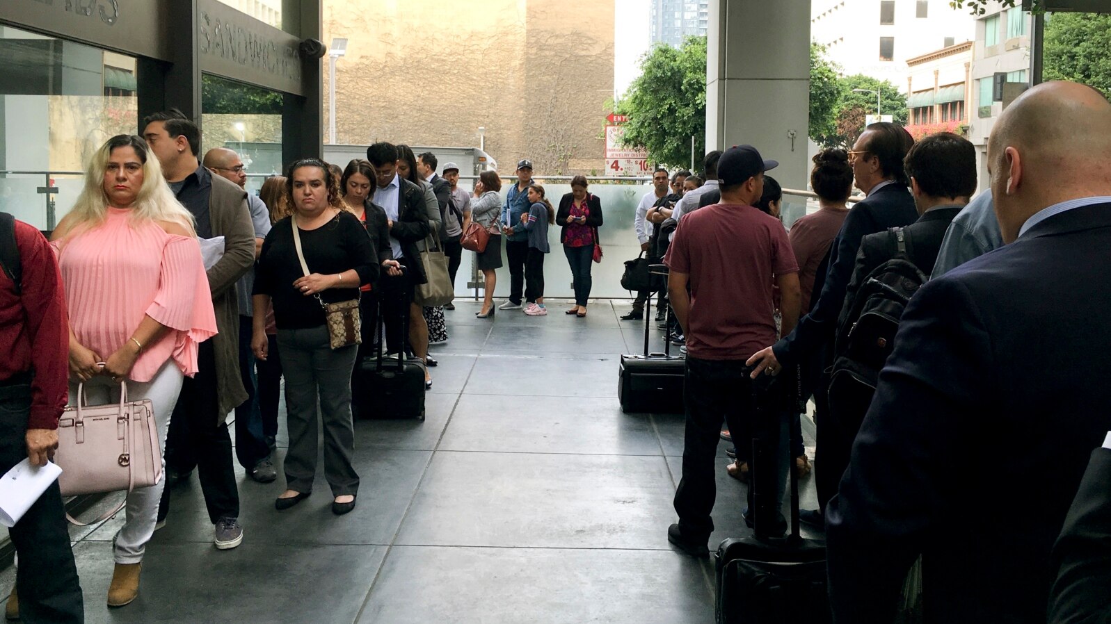 FILE - Immigrants awaiting deportation hearings line up outside the building that houses the immigration courts in Los Angeles, June 19, 2018. 