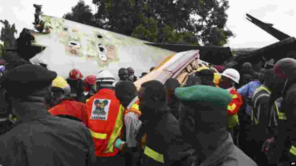 Rescue workers remove a casket with the remains of former Ondo state governor Olusegun Agagu at the site of an Associated airline plane crash In Lagos.