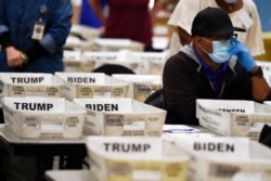 FILE - Cobb County Election officials sort ballots during an audit in Marietta, Ga., Nov. 13, 2020.