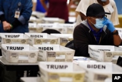 FILE - Cobb County Election officials sort ballots during an audit in Marietta, Ga., Nov. 13, 2020.