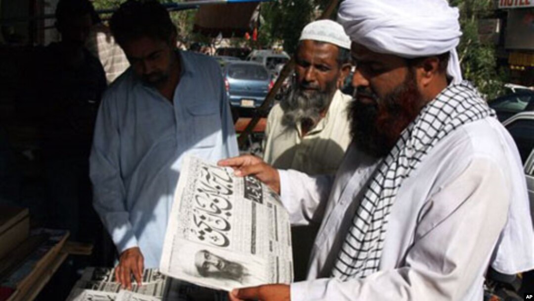People read newspapers at a news stand carry headlines "Osama bin Laden killed." in Hyderabad, Pakistan on Monday, May 2, 2011.