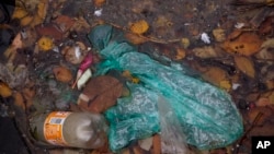 In this Wednesday, Nov. 6, 2019, image, plastic and other garbage floats in a collector of a new device that uses a curtain of tiny air bubbles to catch plastic floating in the capital's canals is seen in Amsterdam, Netherlands. 