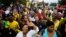 Members of the African National Congress (ANC) and mourners sing to celebrate the life of Nelson Mandela outside his old house in Soweto, Johannesburg, South Africa, Dec. 8, 2013.