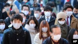 People wearing face masks to protect against the spread of the coronavirus visit Kanda Myojin Shrine on the first business day of the year, in Tokyo, Monday, Jan. 4, 2021. Kanda Myojin is known as the shrine of commerce and industry. (AP Photo/Koji…