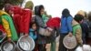 Syrian children queue to receive food distributed by humanitarian aid workers at a makeshift camp for displaced people, near the village of Yazi Bagh, about six kilometers from the Bab al-Salamah border crossing between Syria and Turkey in the north of Aleppo province.