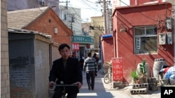 Man rides through the heart of Caochangdi Village