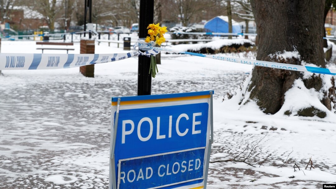 Flowers are left at the cordon near the tent covering the park bench where former Russian intelligence officer Sergei Skripal and his daughter Yulia were found poisoned in Salisbury, Britain, March 19, 2018. 